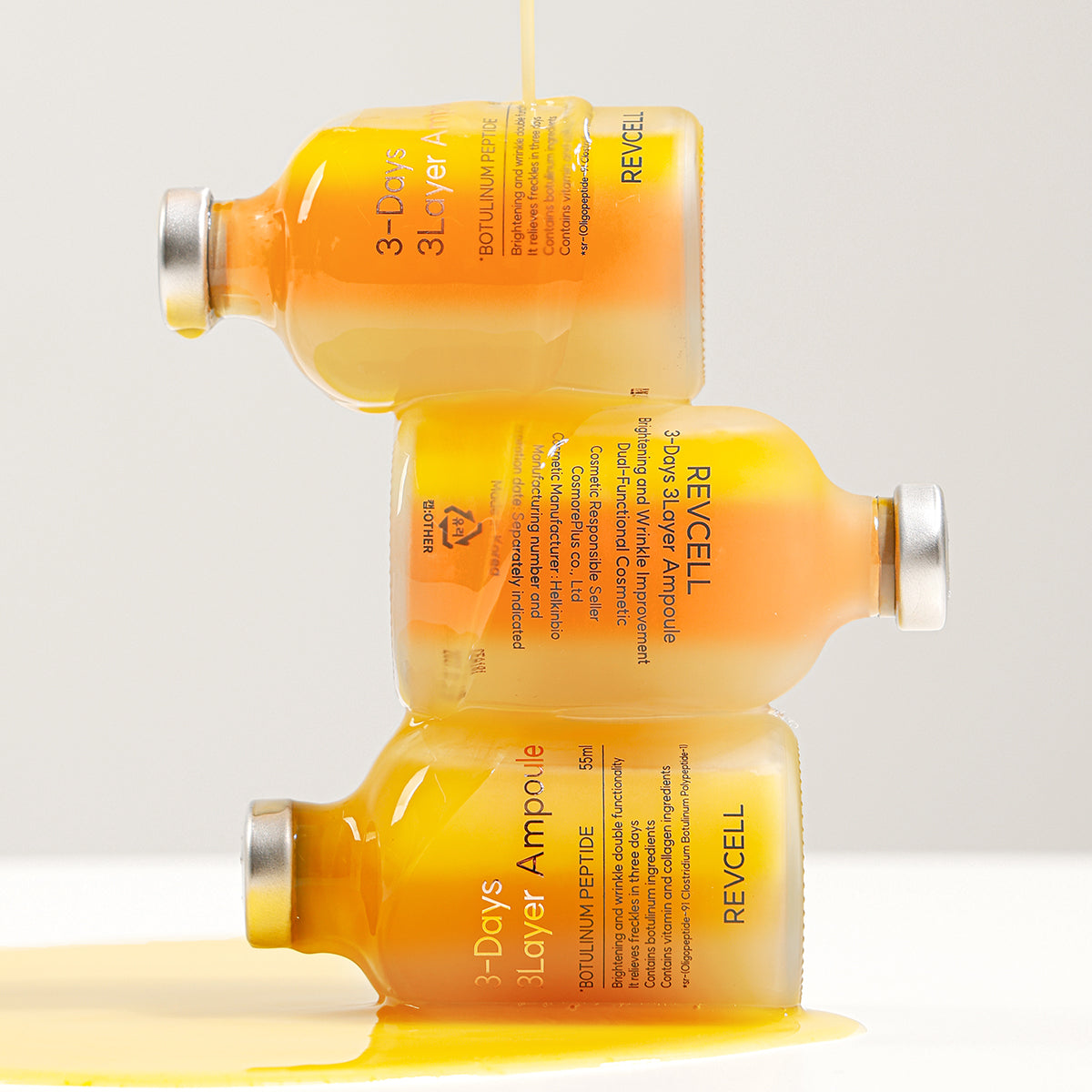 Three bottles of Revcell 3-Days Layer Ampoule on a light gray background