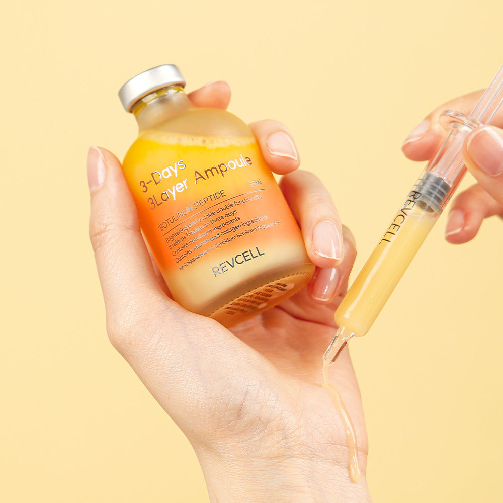 Hand holding a Revcell skincare ampoule bottle with a syringe on a yellow background